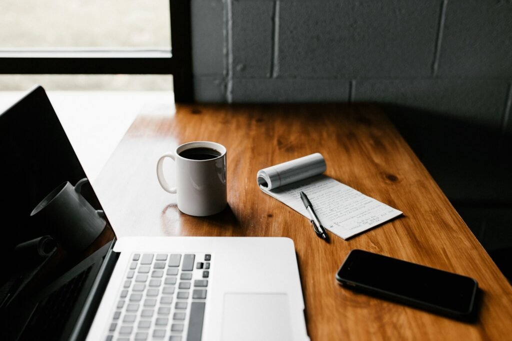 Content writer planning articles in a notebook beside a laptop