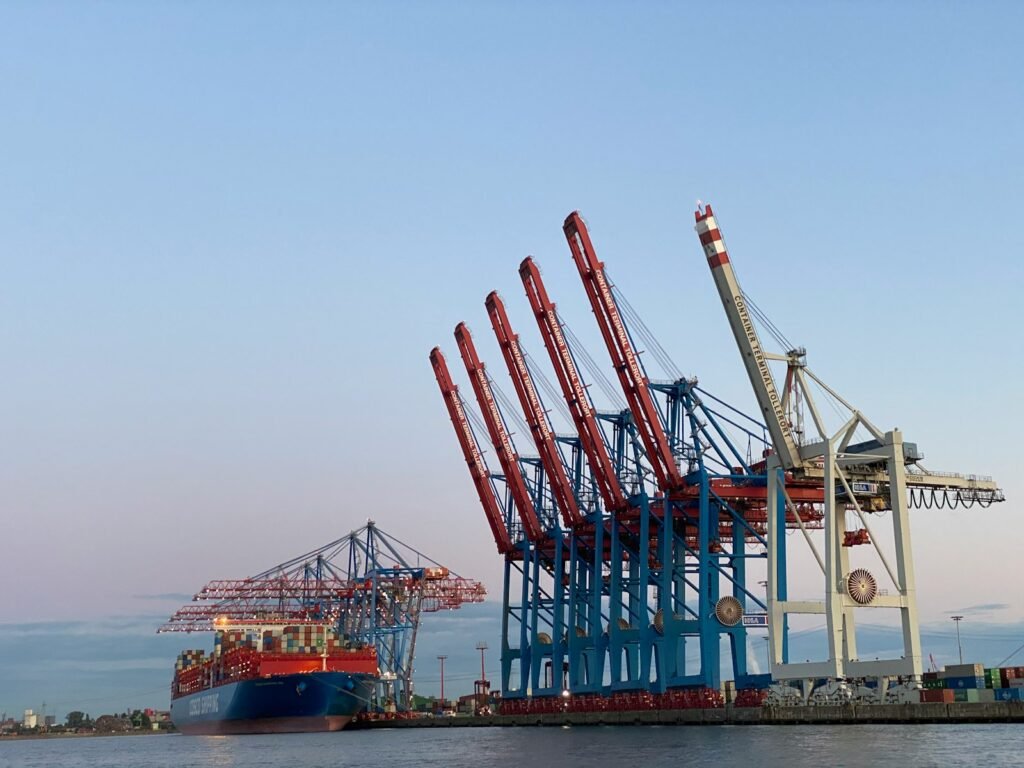 A blue and red cargo ship at sea during the day