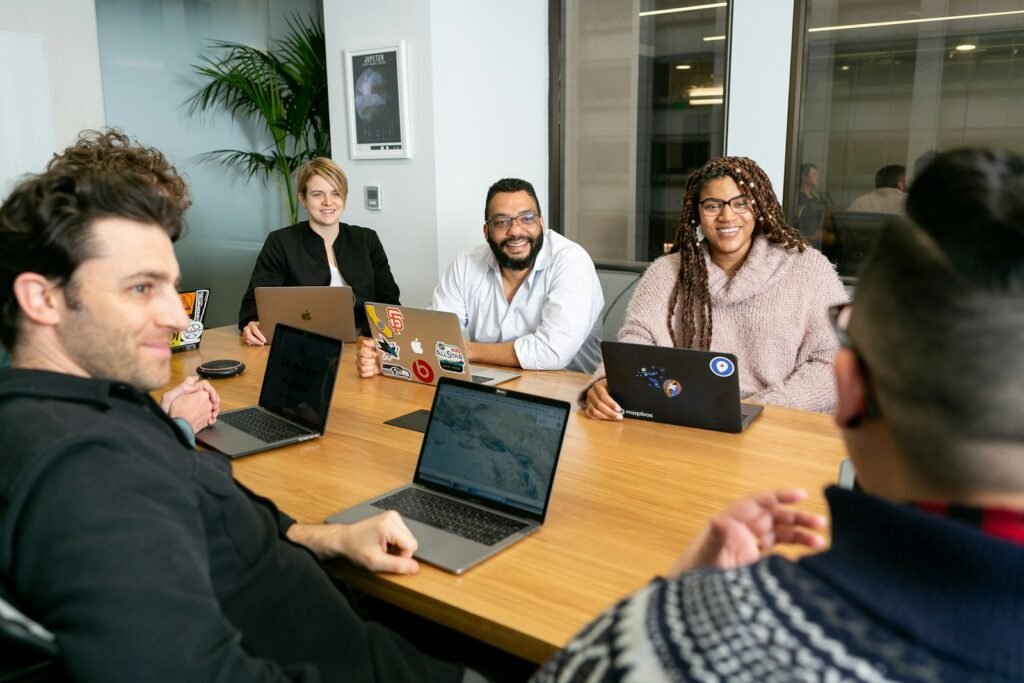 Four people working on laptops during a team meeting