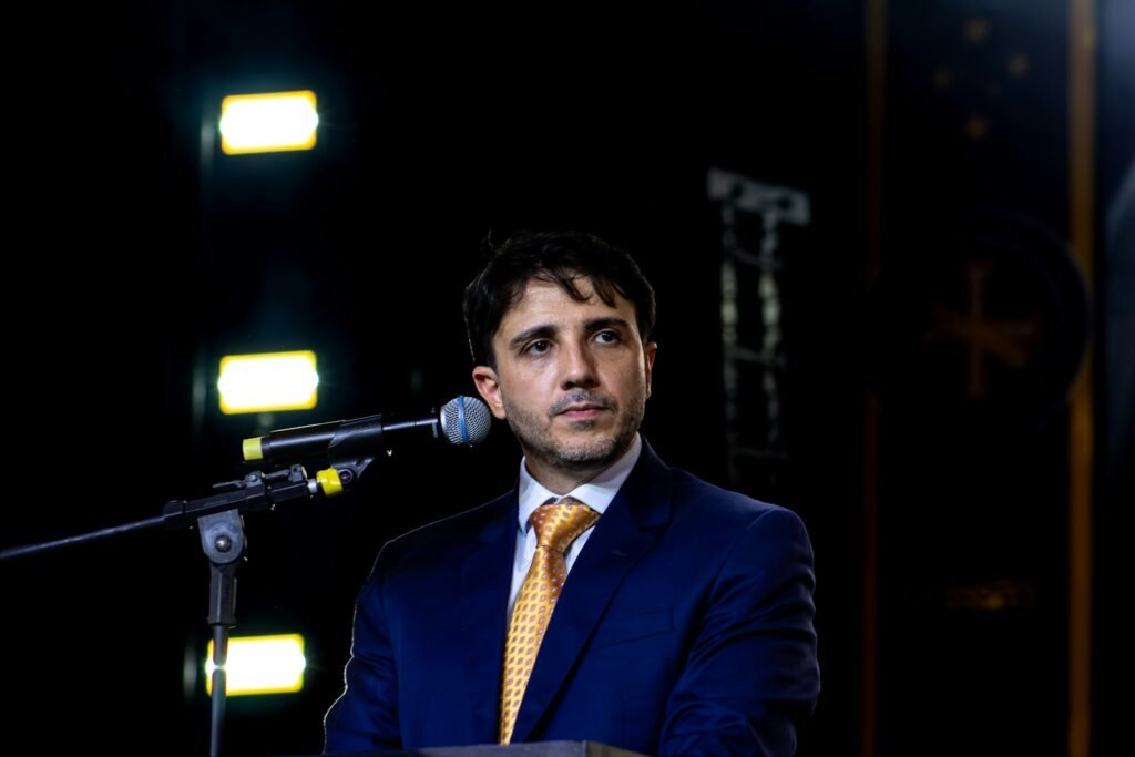A man in a suit speaking at a microphone