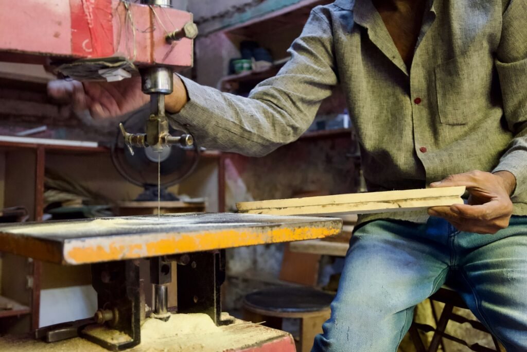A carpenter cutting wood in a small workshop